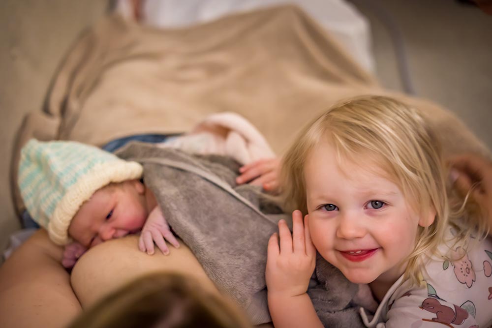 child with newborn sister- home birth photographer leicester