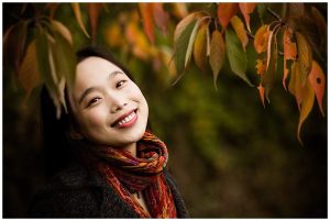 chinese woman in autumn leaves in loughborough